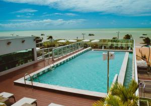 a swimming pool with the beach in the background at Nord Luxxor Tambaú in João Pessoa