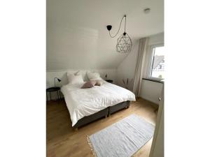 een slaapkamer met een wit bed en een raam bij Holiday home Eifel H time out in Monschau