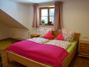 sypialnia z łóżkiem z różową pościelą i oknem w obiekcie Holiday apartment at Gallus Denneberg w mieście Oberstaufen