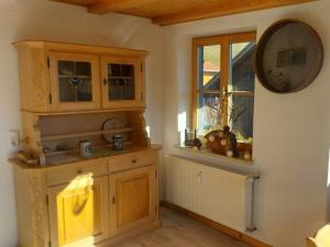 a kitchen with wooden cabinets and a mirror and a window at Holiday apartment Edelweiss in Rieden am Forggensee