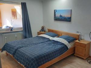 a bedroom with a bed with a blue plaid blanket at Holiday apartment Edelweiss in Rieden am Forggensee