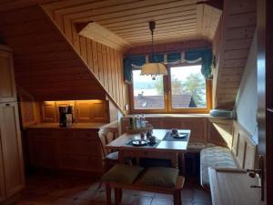 Riegsee的住宿－Holiday apartment Bräu，小屋内的厨房配有桌子和窗户