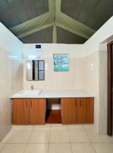 W łazience znajduje się umywalka i lustro. w obiekcie Mara Empiris Safari Camp w mieście Ololaimutiek