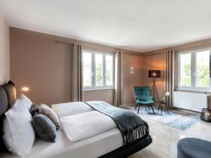 a bedroom with a bed and a chair and windows at Holiday apartment Villa PRIMERA in Singen