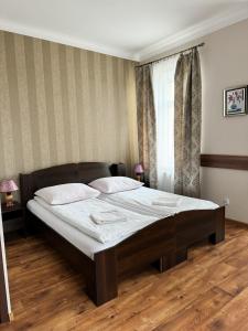 a bedroom with a large bed with white sheets at Villa Carmen in Kudowa-Zdrój