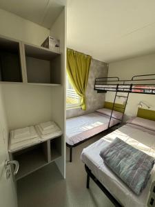 Mały pokój z 2 łóżkami piętrowymi i oknem w obiekcie Campeggio Madonna Del Ghisallo w mieście Magreglio