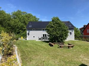una casa blanca con un montón de troncos en el patio en Holiday home - Bimmelbahn 2, en Olbersdorf