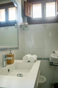 a white bathroom with a sink and a mirror at La Fuentona de Ruente in Ruente