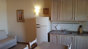 a kitchen with a refrigerator and a table and a sink at Una Finestra sul Silenzio Monolocale in Santa Luce