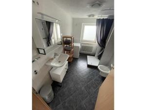 uma casa de banho com um lavatório e um WC em Holiday apartment Talblick em Unterlenningen