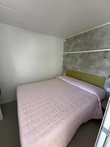 a small bedroom with a pink bed in it at Campeggio Madonna Del Ghisallo in Magreglio