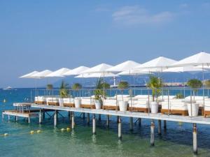 a pier with chairs and umbrellas on the water at Holiday Cottage in Provence in Montauroux
