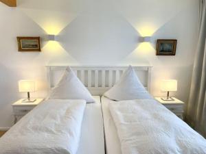 two white beds with white pillows in a bedroom at Holiday apartment Seeloft in Konstanz