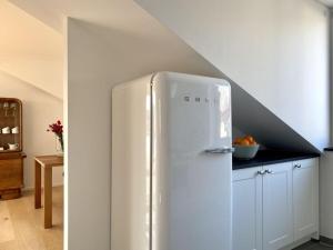 a white refrigerator in a kitchen with a staircase at Holiday apartment Seeloft in Konstanz