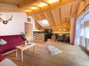 a living room with a red couch and a kitchen at Holiday apartment d'griabige in Farchant