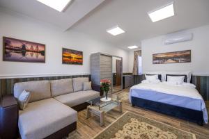 un dormitorio con una cama y un sofá en Vörös Álom Apartman Panzió, en Tiszakécske 61 fotos más