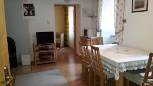 a living room with a table and a television at Landhaus zum Siebenschläfer in Herrnbaumgarten