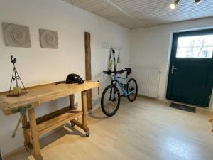 a bike in a room with a desk and a door at Holiday apartment Landzauber in Heideck