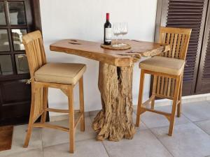 einen Holztisch mit 2 Stühlen und eine Flasche Wein in der Unterkunft Bungalow Villa del Sol in Morro del Jable