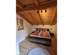 a bedroom with a bed in a room with wooden ceilings at Susanne - forest holiday village 