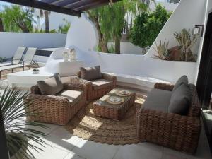 eine Terrasse mit Korbstühlen und einem Tisch auf der Terrasse in der Unterkunft Bungalow Villa del Sol in Morro del Jable