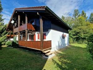 a small house with a porch and a balcony at Susanne - forest holiday village 