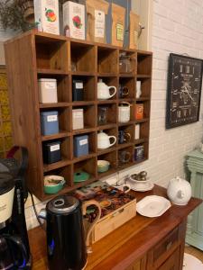 un comptoir de cuisine avec une étagère de tasses et de vaisselle dans l'établissement Maison d'Hôtes de l'Ancien Couvent des Carmes, à Mortemart