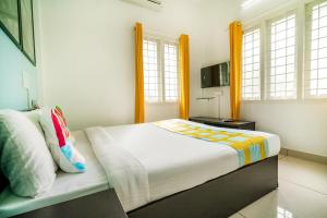 sypialnia z dużym łóżkiem i oknami w obiekcie Super OYO Thykoodam Apartments w mieście Koczin