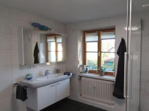 a white bathroom with a sink and a shower at Holiday apartment Alpenrose in Rieden am Forggensee +33 photos