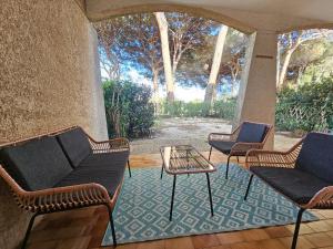 a group of chairs and tables on a patio at Appartement golf de Valescure avec jardin in Saint-Raphaël