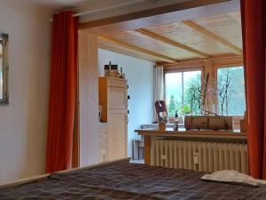 a room with a bed and a kitchen with a window at Holiday apartment Alpenrose in Rieden am Forggensee