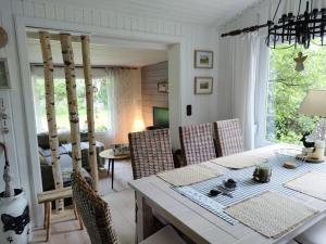 a dining room with a table and chairs and a living room at Holiday home fairytale hut in Biedenkopf