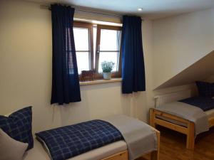 a bedroom with a bed and a window with blue curtains at at Gallus - Wetterstein in Oberstaufen