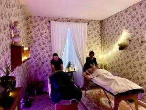 Mortemart的住宿－Maison d'Hôtes de l'Ancien Couvent des Carmes，两名妇女坐在房间里的床上