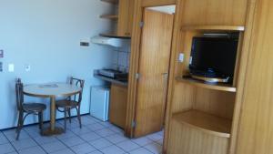 a small kitchen with a small table and a television at Classic Residence Beira Mar in Fortaleza
