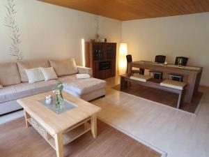 uma sala de estar com um sofá e uma mesa em Holiday apartment in the garden em Eppenbrunn