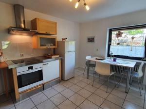 uma cozinha com um frigorífico e uma mesa com cadeiras em Holiday apartment in the garden em Eppenbrunn