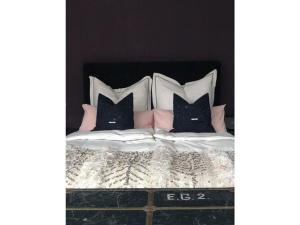 a bed with pink and white pillows on it at Apartment KEMENATE14 in Seeshaupt