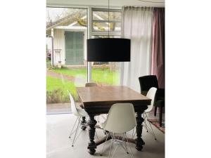 a dining room table with white chairs and a lamp at Apartment KEMENATE14 in Seeshaupt