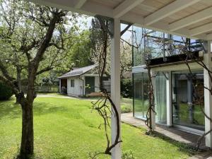 a house with a green yard with a tree at Apartment KEMENATE14 in Seeshaupt