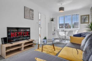 a living room with a couch and a tv at Modern 3BR Home in 9 Anson Rd Near Sandwell Hospital with Garden and Free Parking in West Bromwich