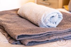a pile of towels sitting on top of a bed at Modern 3BR Home in 9 Anson Rd Near Sandwell Hospital with Garden and Free Parking in West Bromwich +62 photos