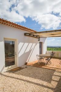 a patio with a table and chairs next to a building at Costa Vicentina cottage with a view in Cercal