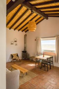 a living room with a table and chairs and a window at Costa Vicentina cottage with a view in Cercal