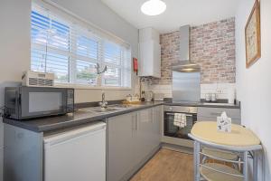 a kitchen with a sink and a microwave at Stylish Comfort, Near Auckland Castle, Sleeps 4 in Crook