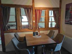 a dining room with a table and chairs and windows at Holiday apartment Bergwiese in Lenzkirch