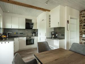 a kitchen with white cabinets and a wooden table at Holiday apartment Bergwiese in Lenzkirch
