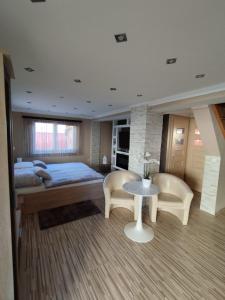 1 dormitorio con 1 cama, mesa y sillas en Édenkert Apartmanház en Kisvárda