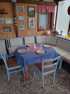 a table with a blue table cloth and chairs and a couch at Ferienwohnung Hilla in Taben-Rodt