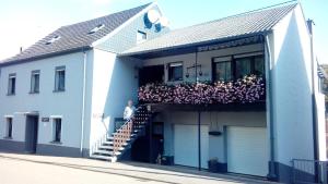 a man standing on the balcony of a house at Ferienwohnung Hilla in Taben-Rodt